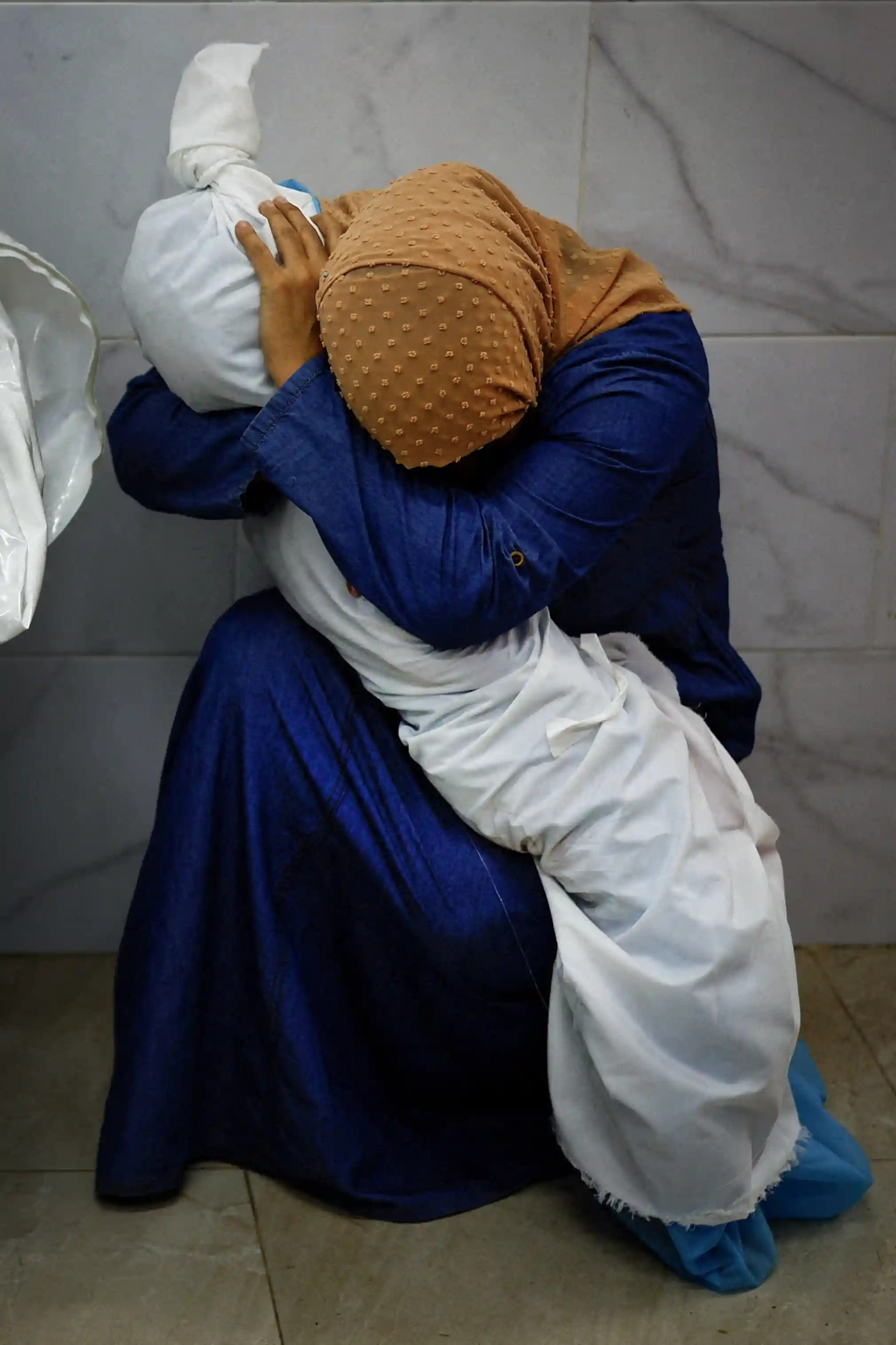 a_palestinian_woman_embraces_the_body_of_her_niece_by_mohammed_salem_1.jpg