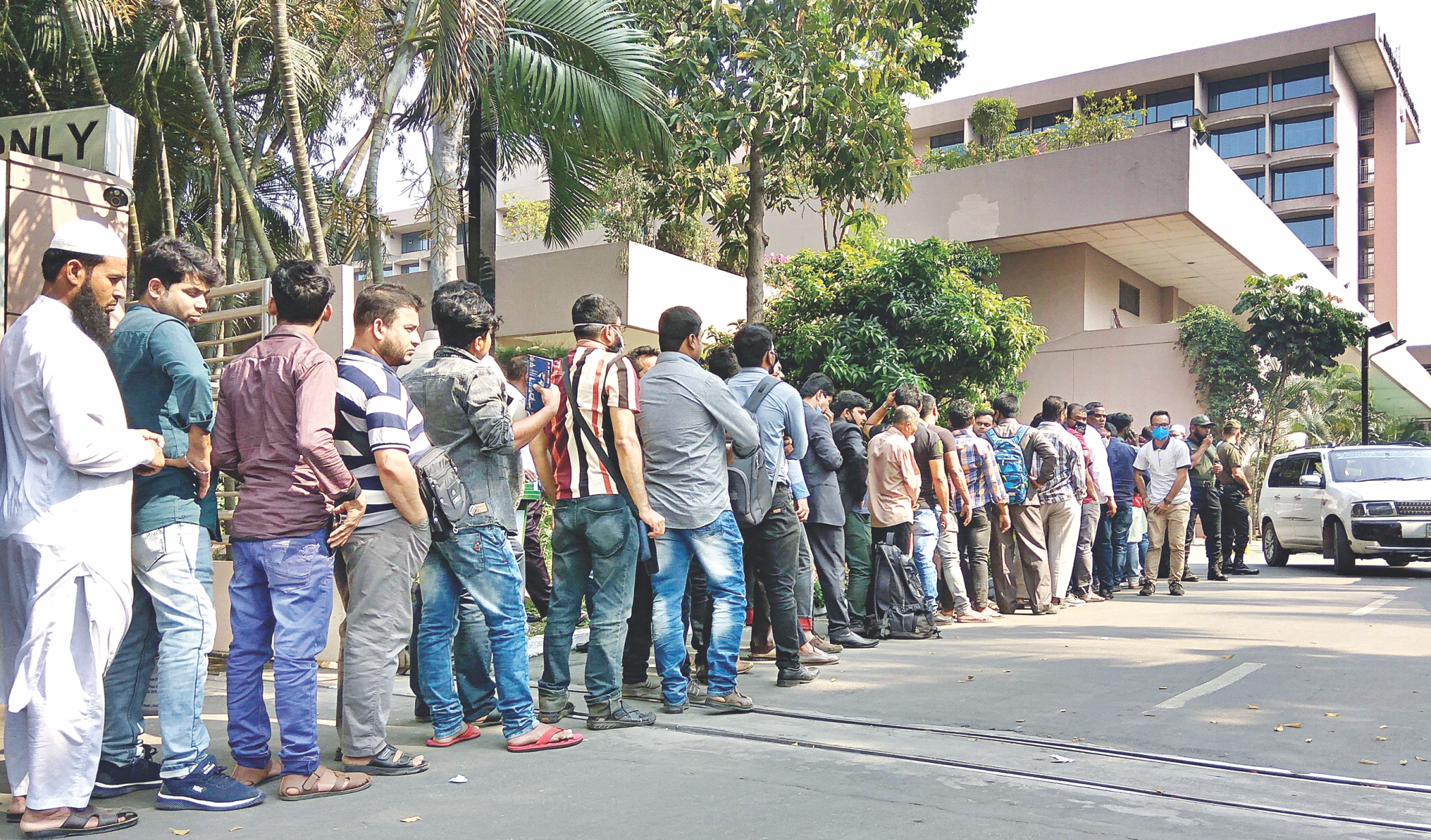 Migrant workers waiting in a long queue on the Sonargaon hotel 
